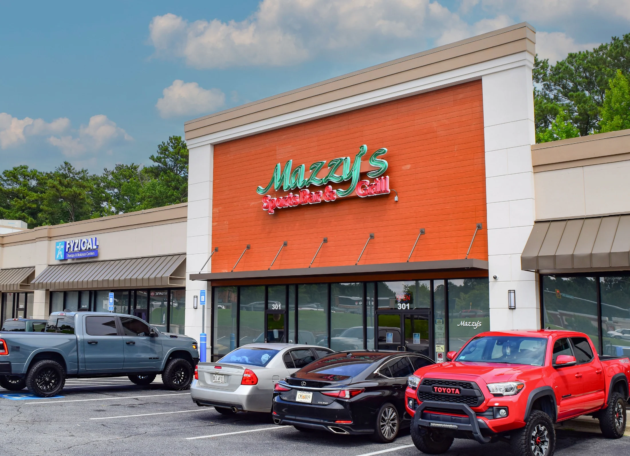 Mazzy's Sports Bar & Grill storefront with parking in the foreground